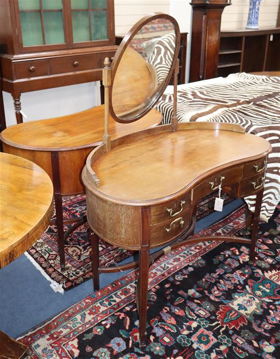 A pair of 1920s mahogany kidney shaped dressing tables, one with an oval mirror W.100cm